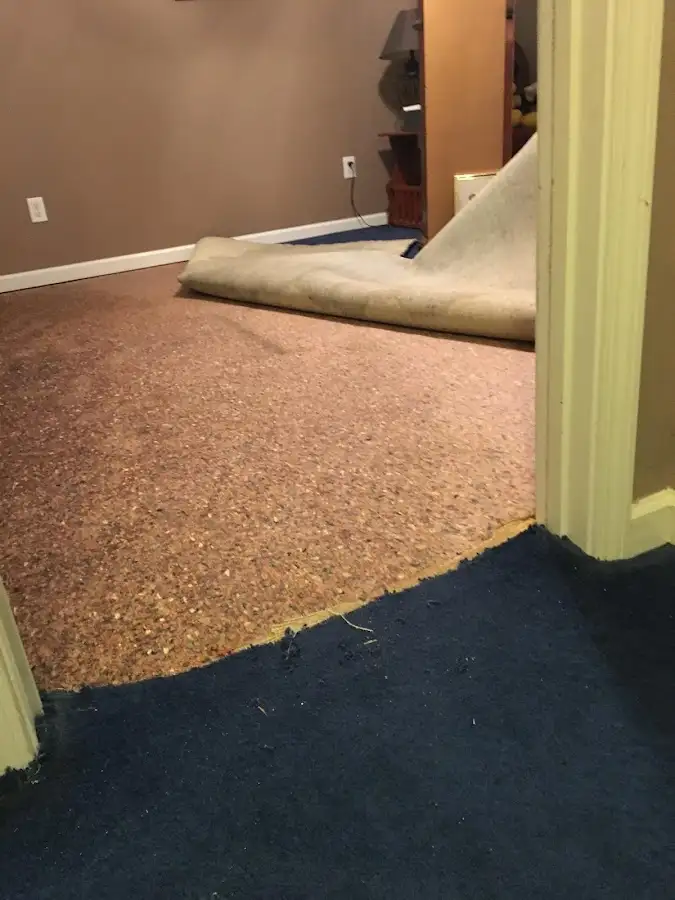 Carpet pad removal revealing water damage during Water Mitigation Services in De Queen